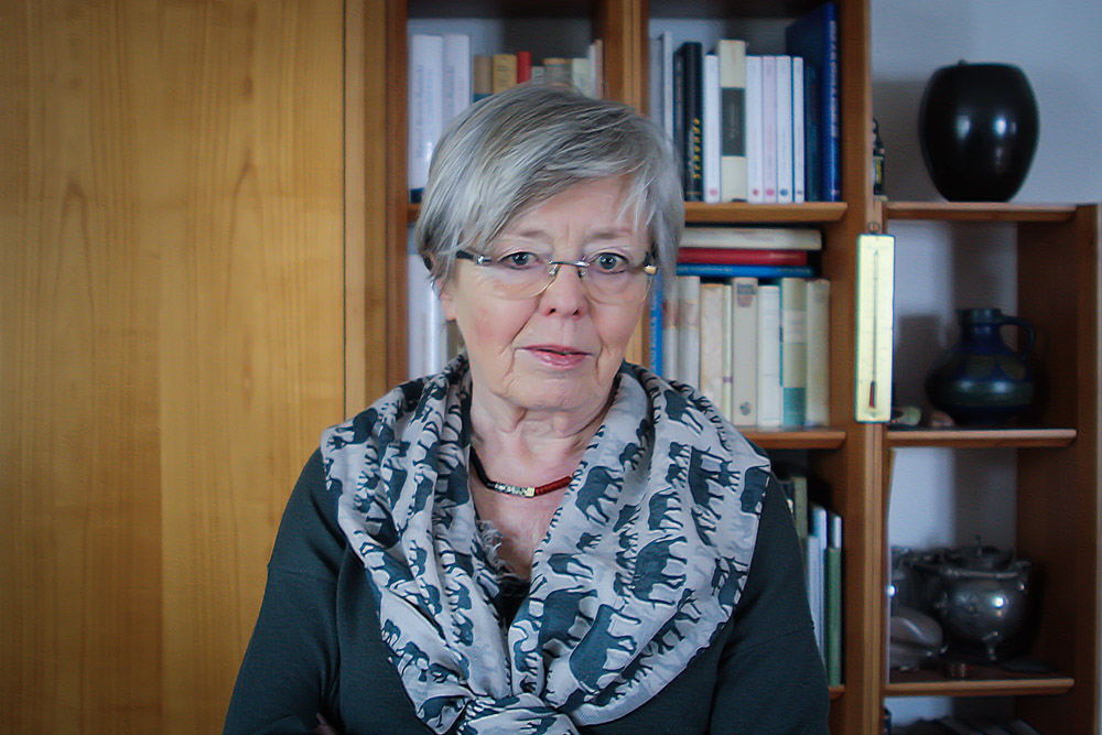 Brigitte Kaissling vor einem Büchergestell stehend