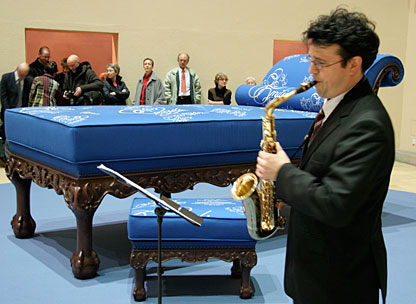 Saxophonist mit Chaiselongue im Hintergrund